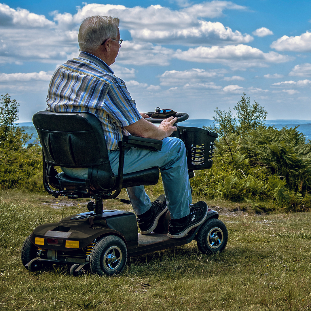 Showing Vantage Mobility Scooter Being driven over Grass near a beach.
