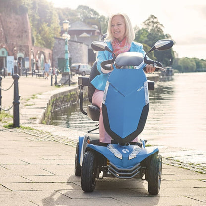 Showing the Rascal Vecta Sport being driven by a lady on a summers day near a river. She looks happy and stylish on her new scooter